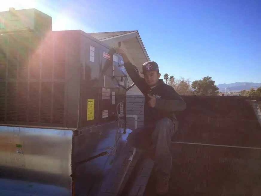 HVAC technician performing AC Tune-Up on a rooftop unit in Longmont